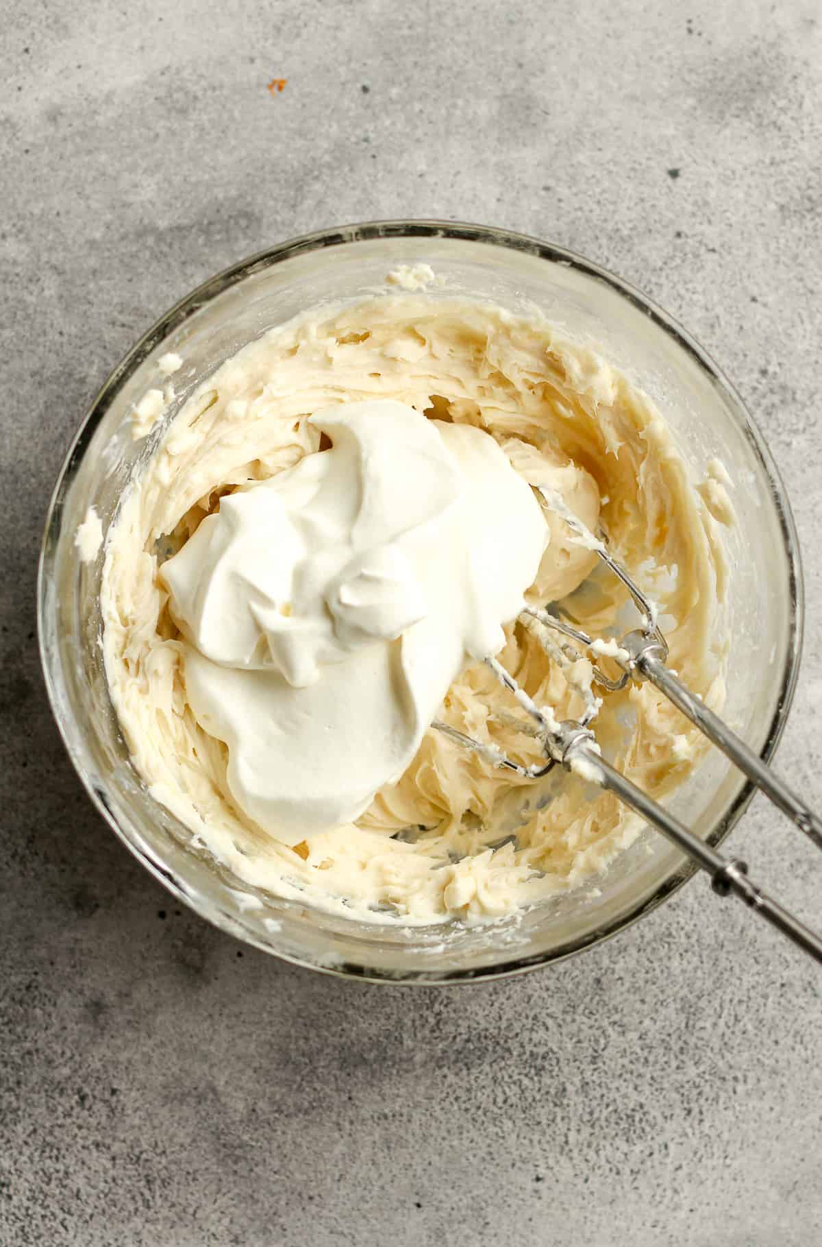 A bowl of the dip with the whipping cream on top.
