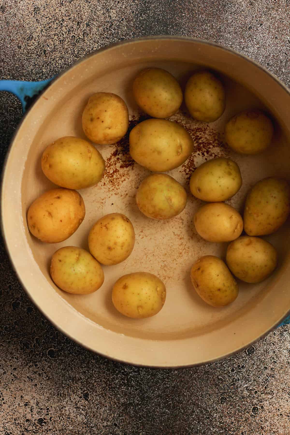 The pot of baby potatoes filled with water.