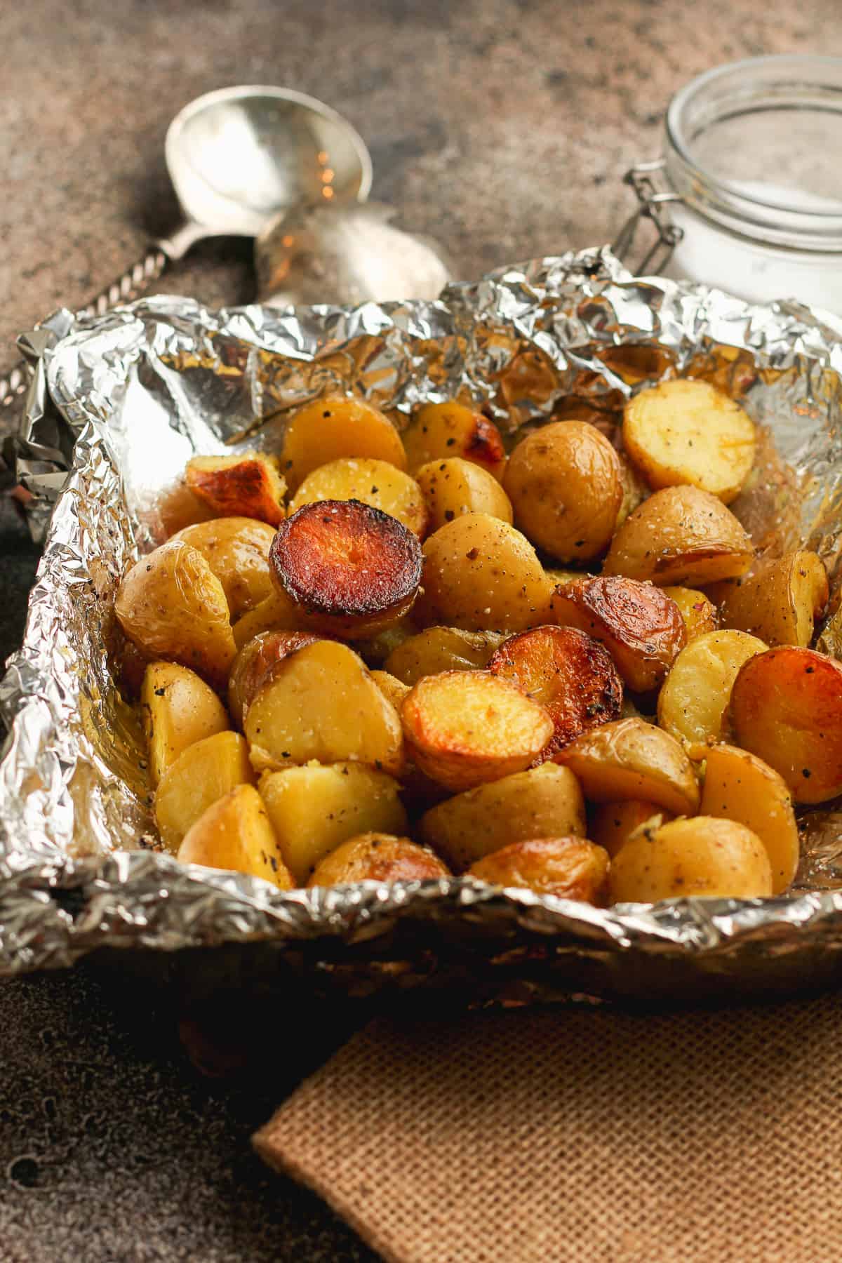 Side view of a tin full of grilled baby potatoes.