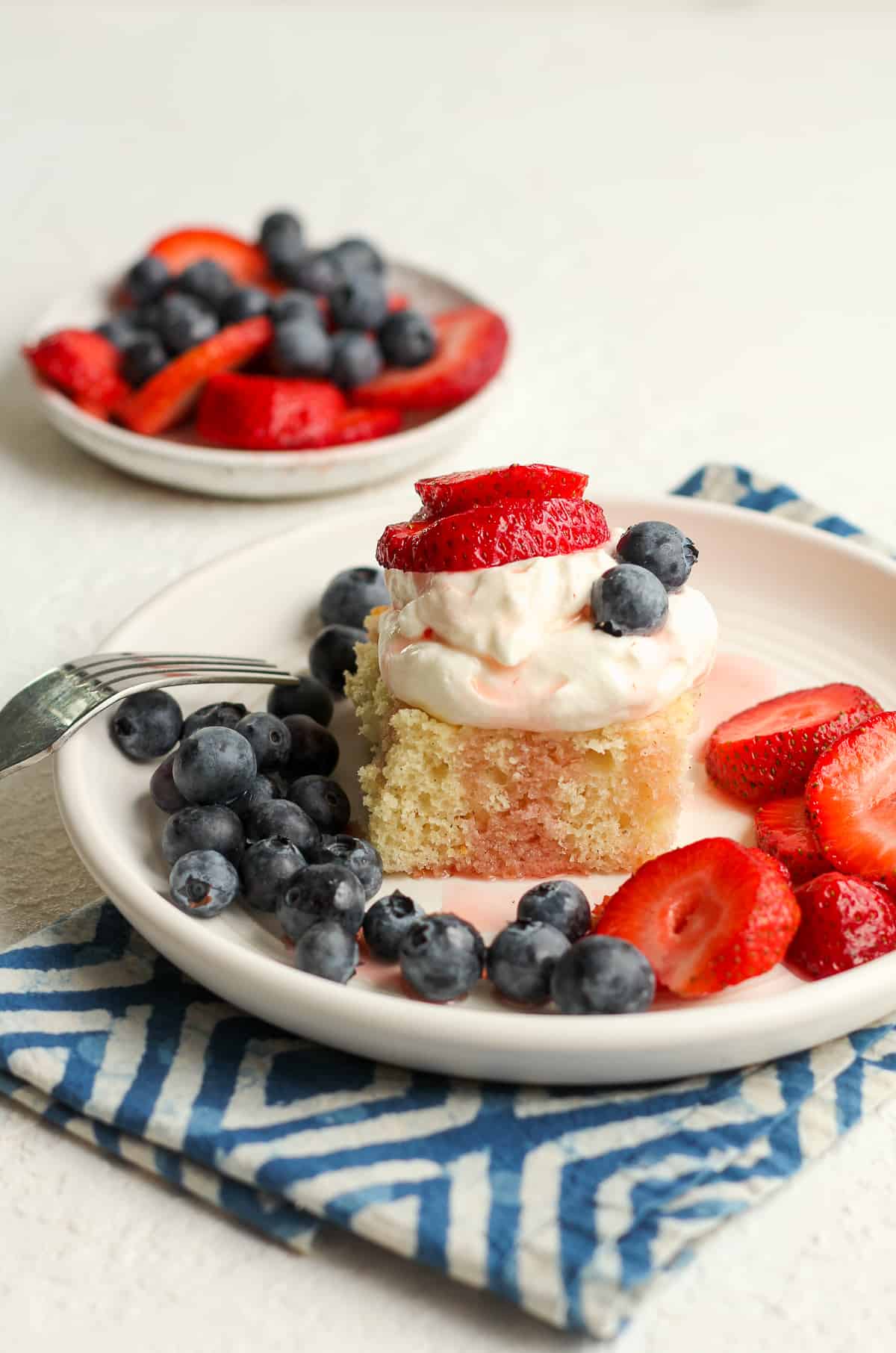 Side view of a piece of shortcake with blueberries and strawberries.
