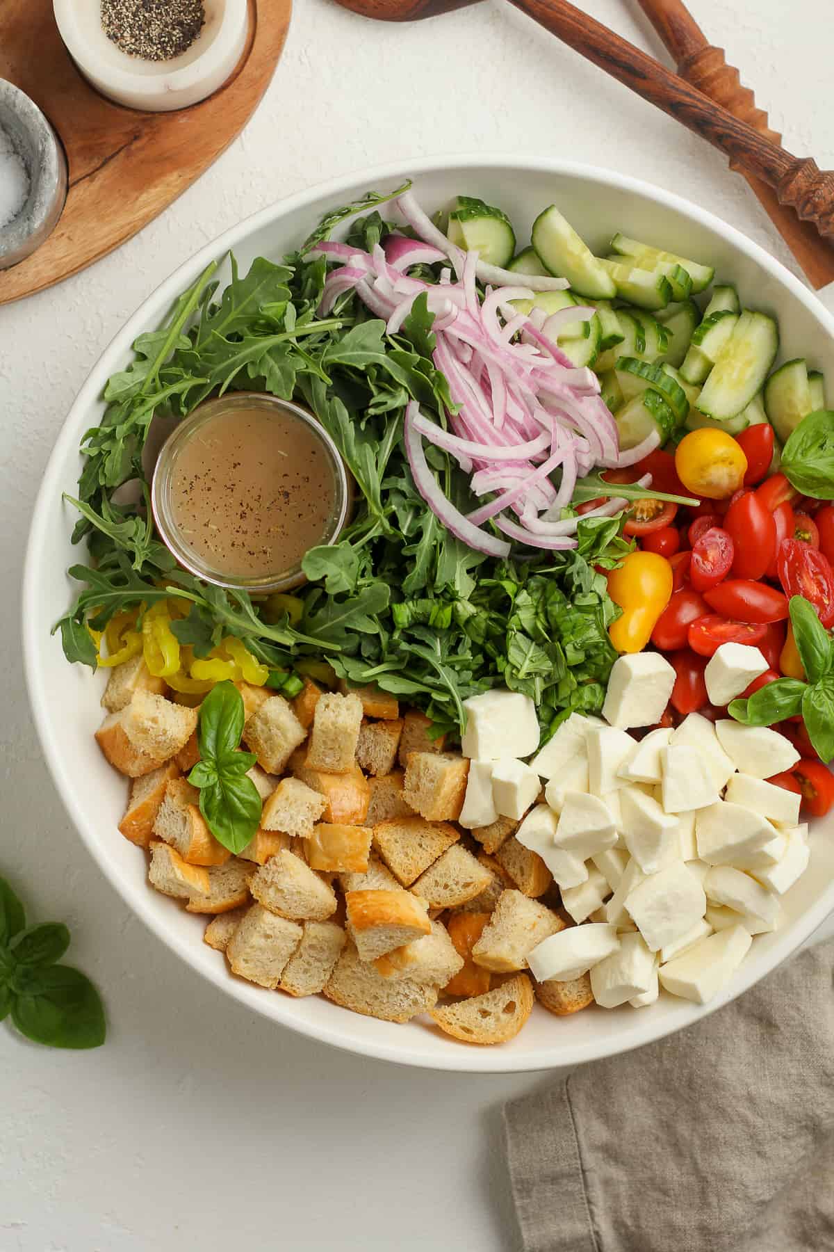 A large bowl of the panzanella, separated by ingredient.