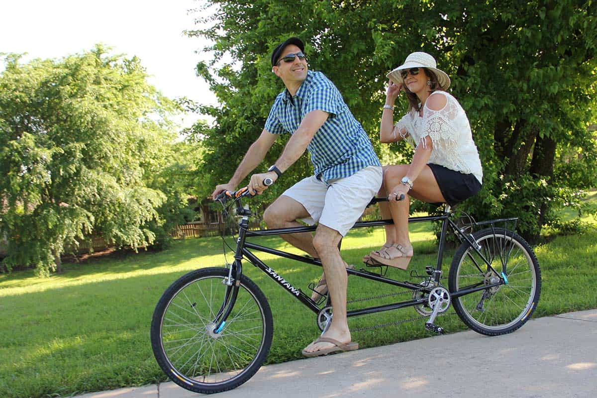 A photo of Mike and I riding a tandem bike on a trail in a nearby park.