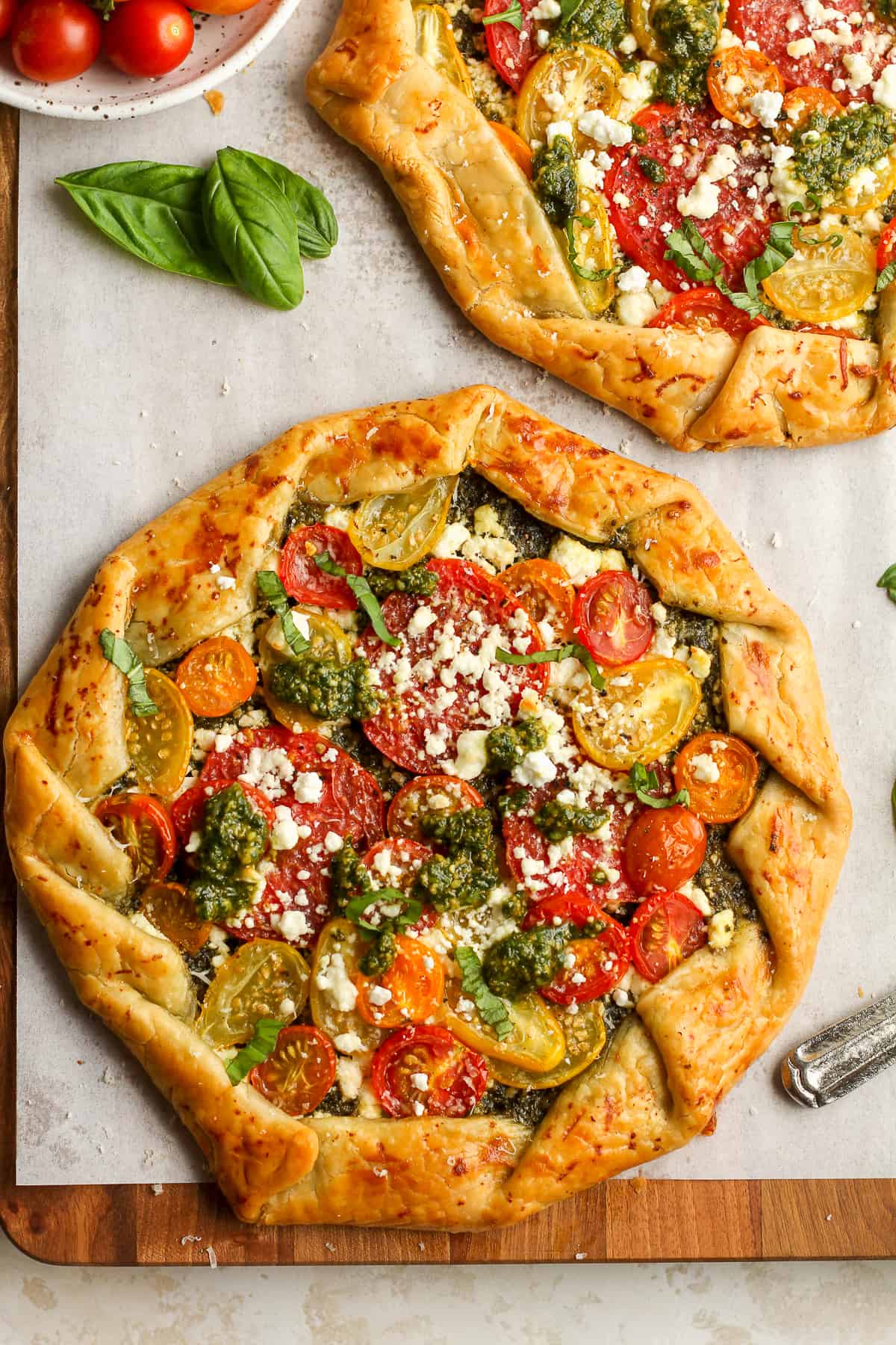 Two tomato galettes with fresh basil.
