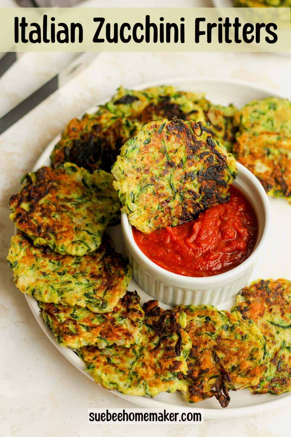 A plate of Italian zucchini fritters with a bowl of sauce in the middle.