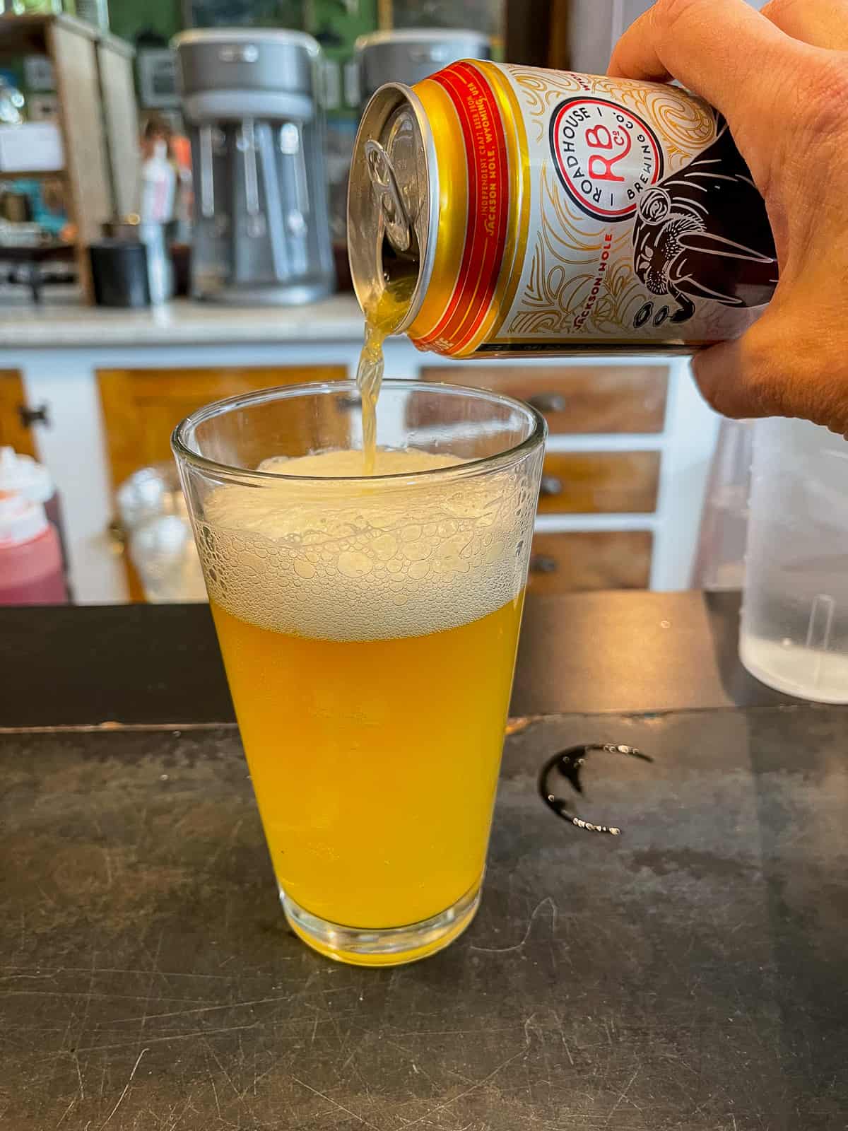 A hand pouring a beer into a glass.