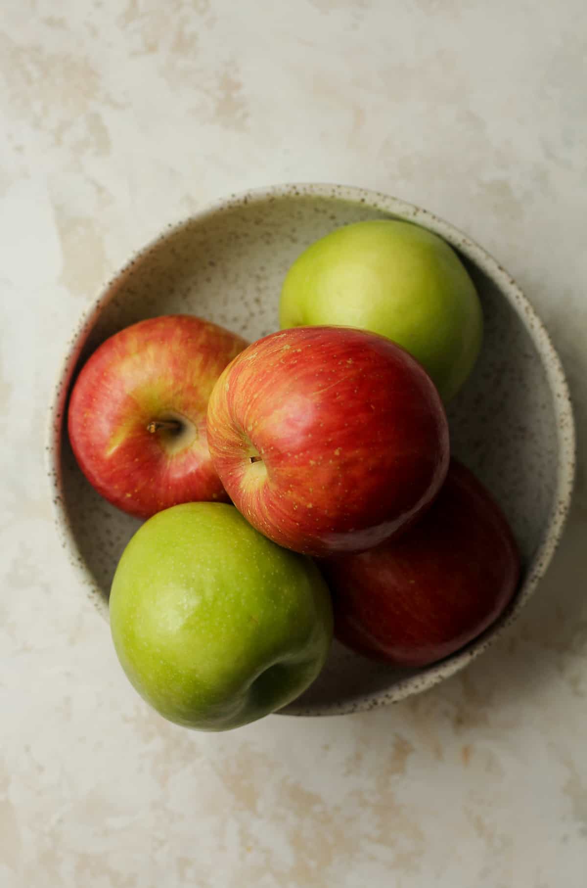 A bowl of the red and green apples.