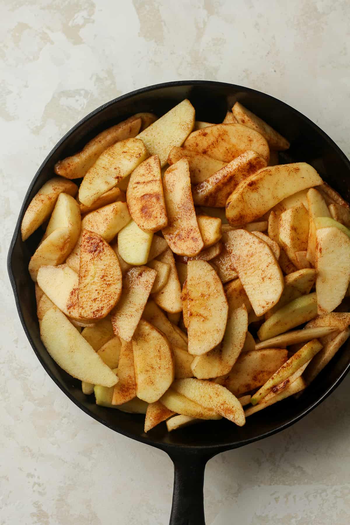 A skillet of the sugared sliced apples.