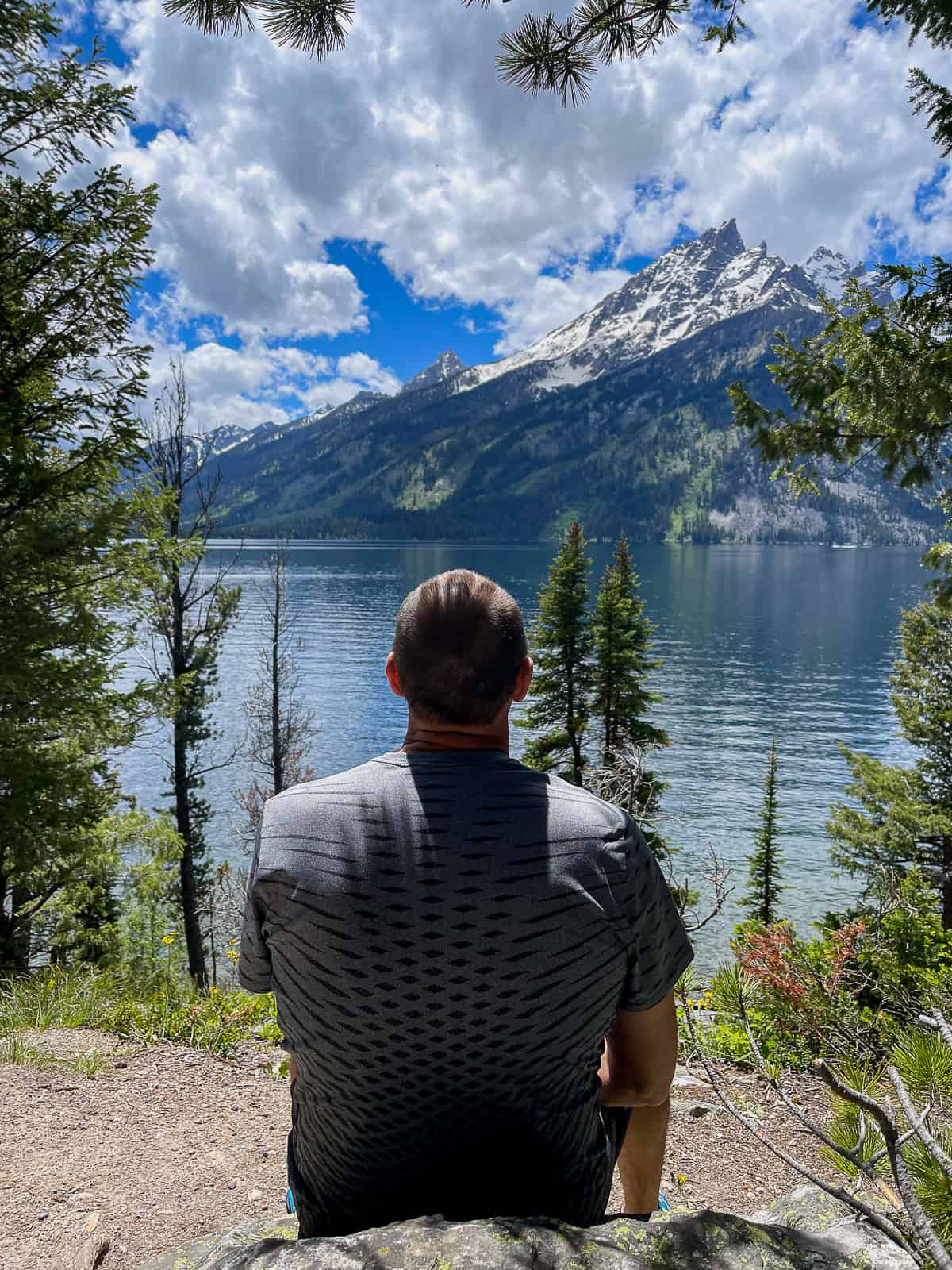 Mike sitting on a rock looking at Jenny Lake.