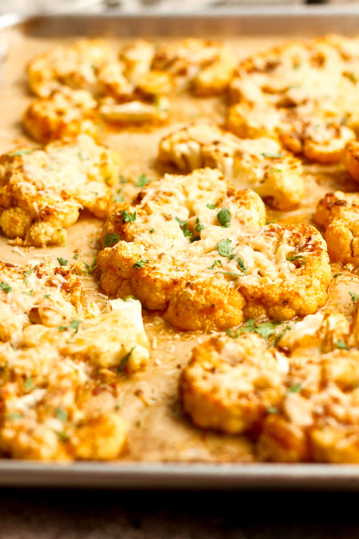 Side view of a pan of cheesy cauliflower steaks.