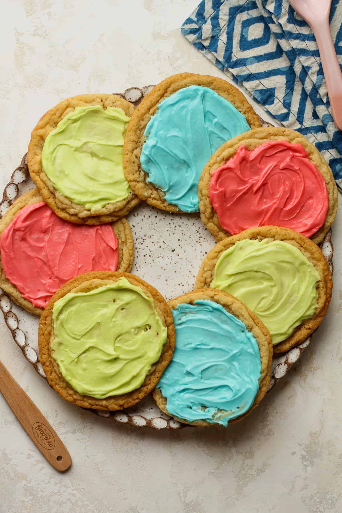 A plate of frosted sugar cookies with green, blue, and red frosting.