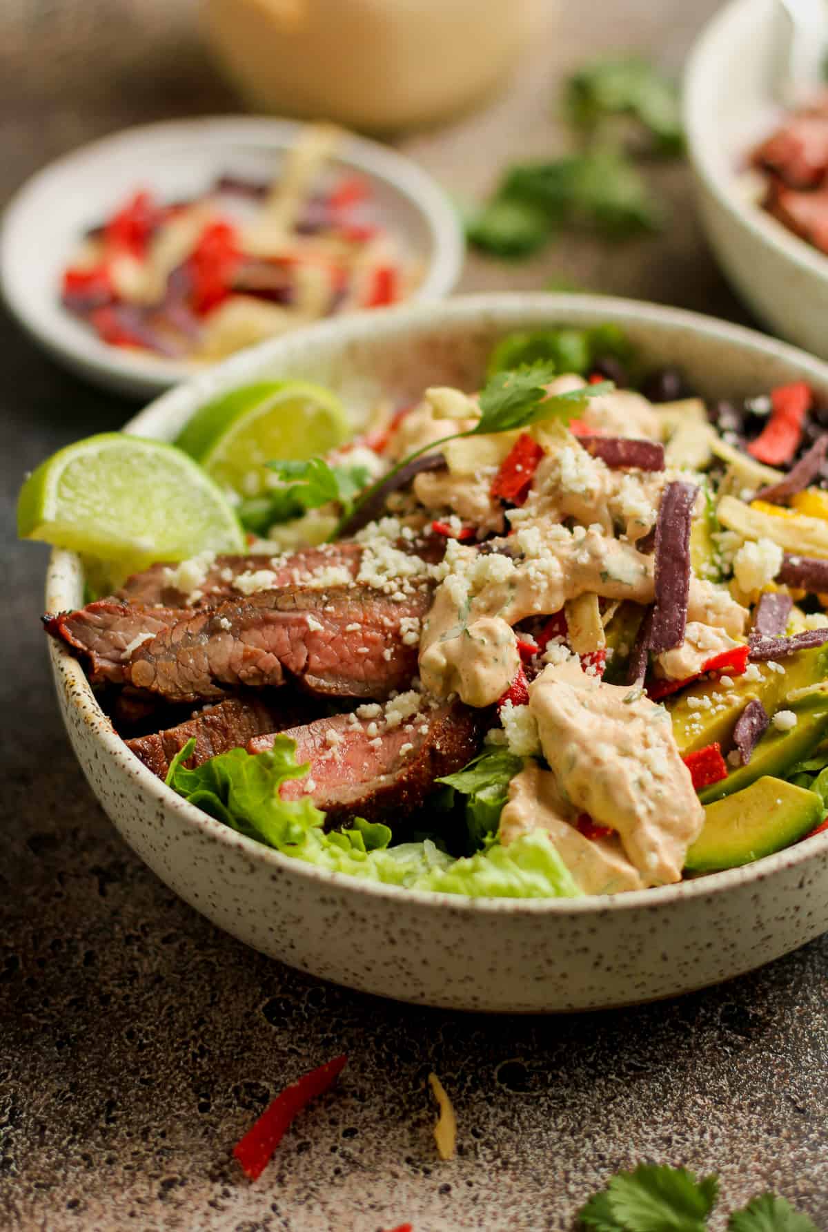 Side view of a fajita steak taco salad with chipotle ranch.