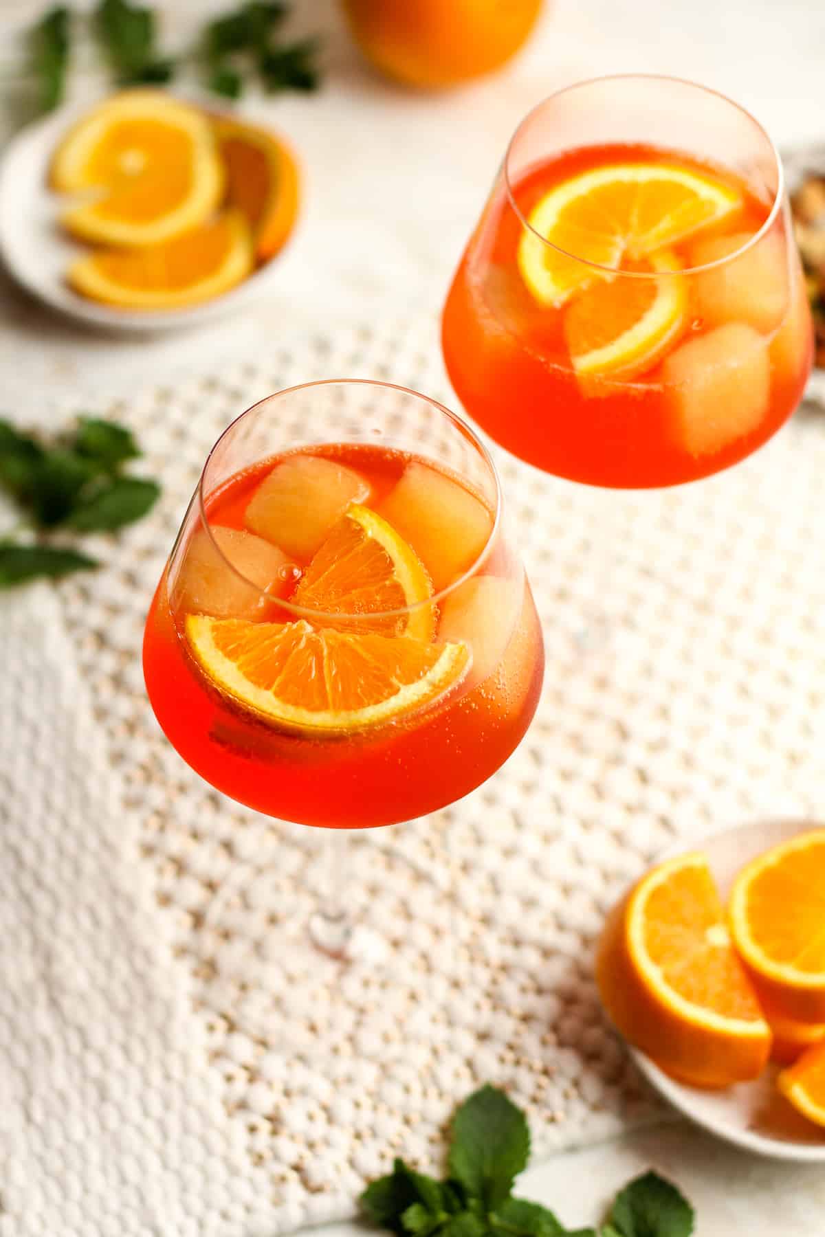 Overhead view of two aperol spritz with orange slices.