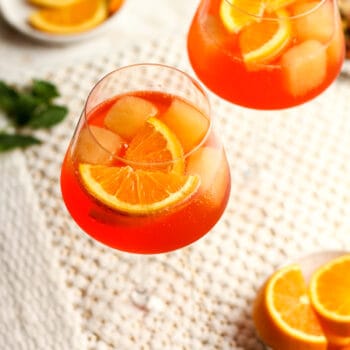 Overhead shot of two glasses of aperol spritz with orange slices.
