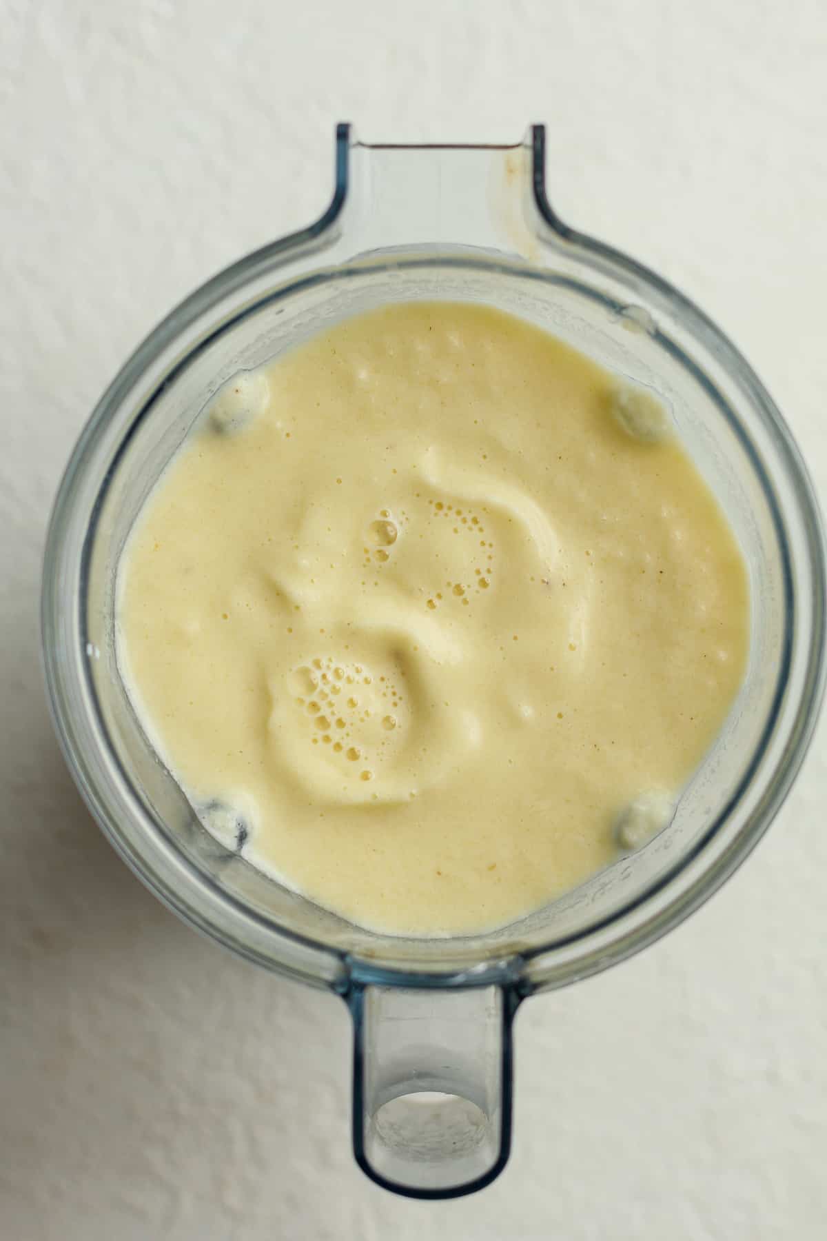 A blender of frozen pineapple banana smoothie mixture.
