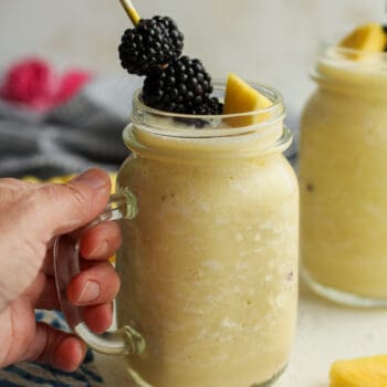 A hand on a pineapple banana smoothie.
