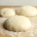 Side view of homemade pizza dough rounds.