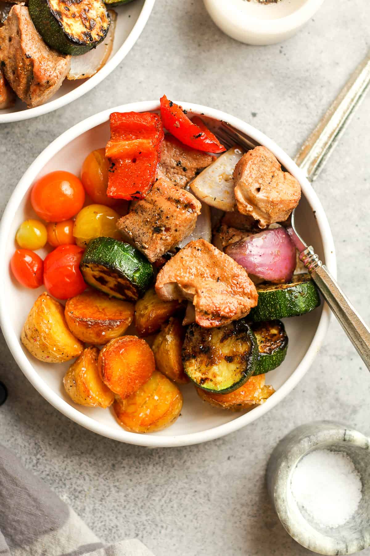 A bowl of the pork and veggies with a fork.