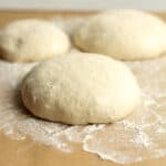 Side view of three rounds of pizza dough.