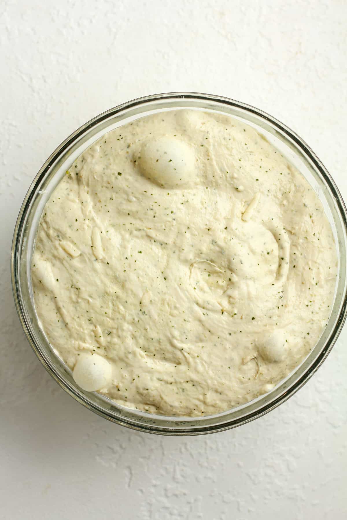 A bowl of the sourdough after rising, with bubbles.