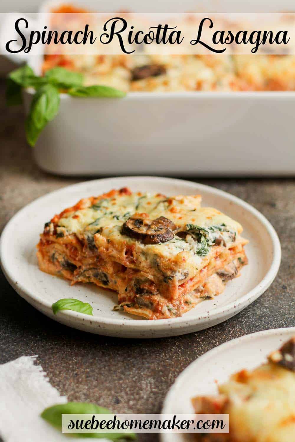 A square of spinach lasagna with ricotta with the casserole in the background.