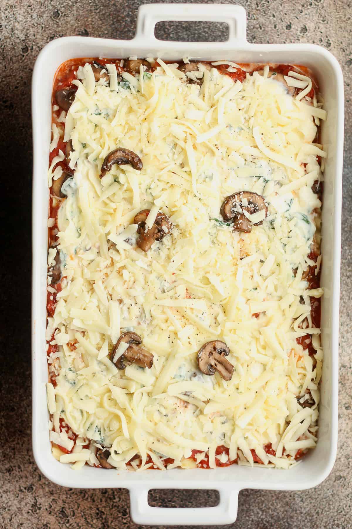 A large casserole of spinach lasagna before baking.