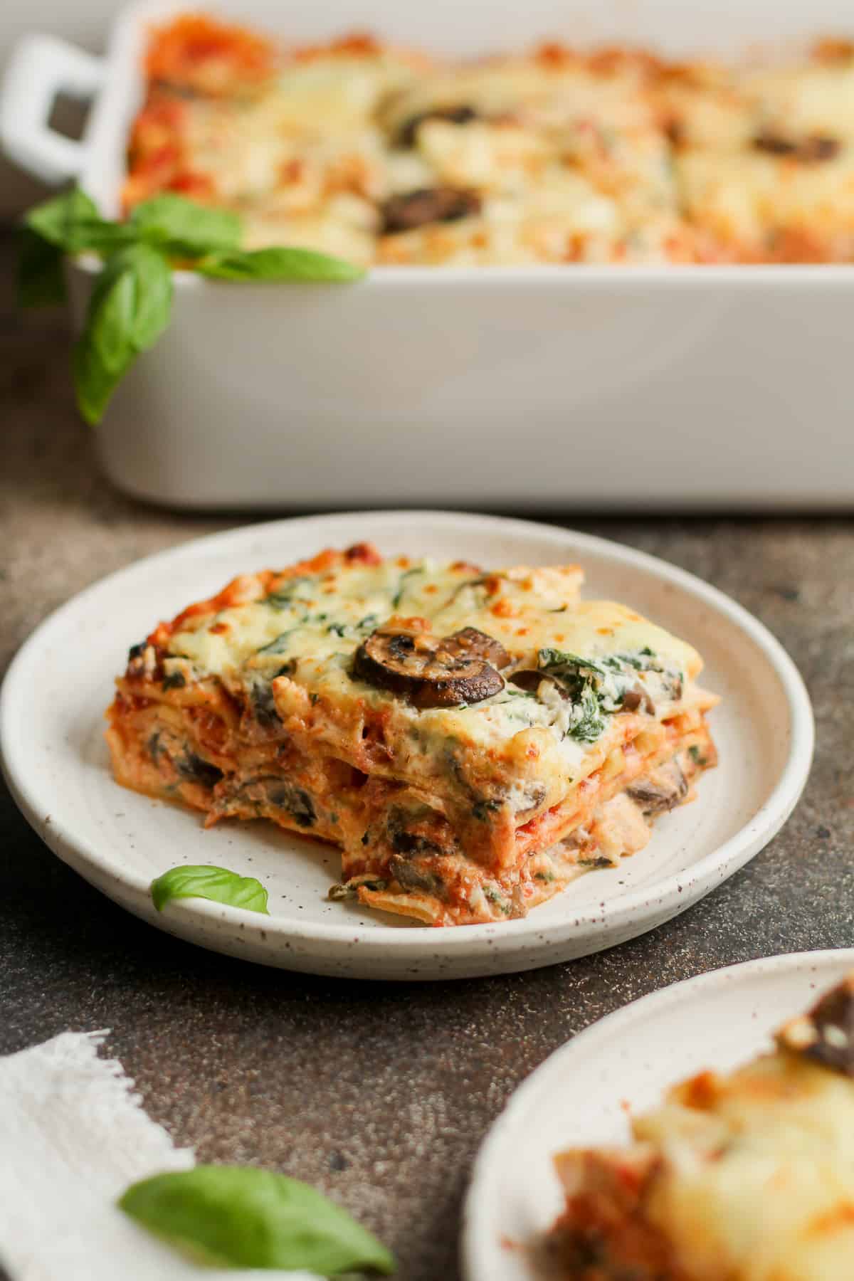A plate of spinach ricotta lasagna with mushrooms.