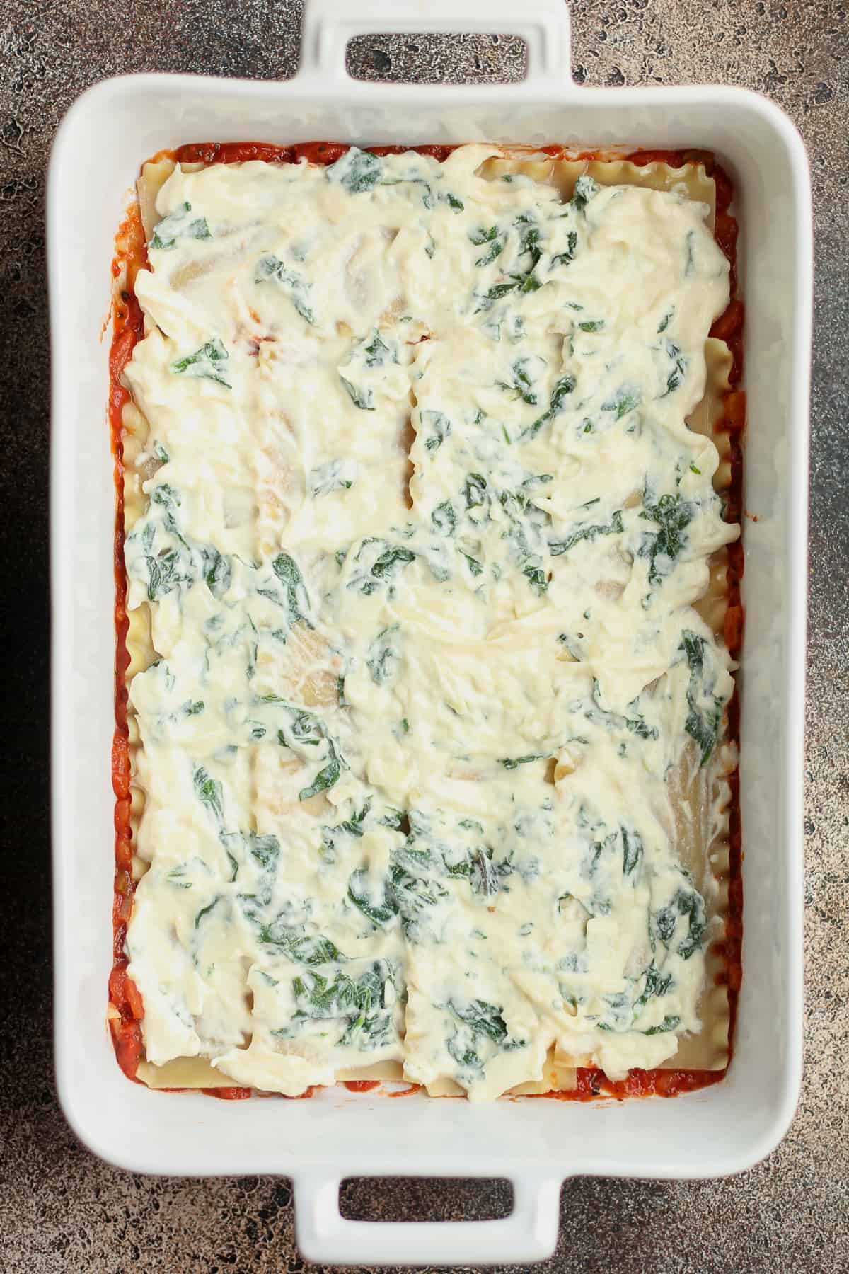 The casserole layers with the ricotta and spinach on top.