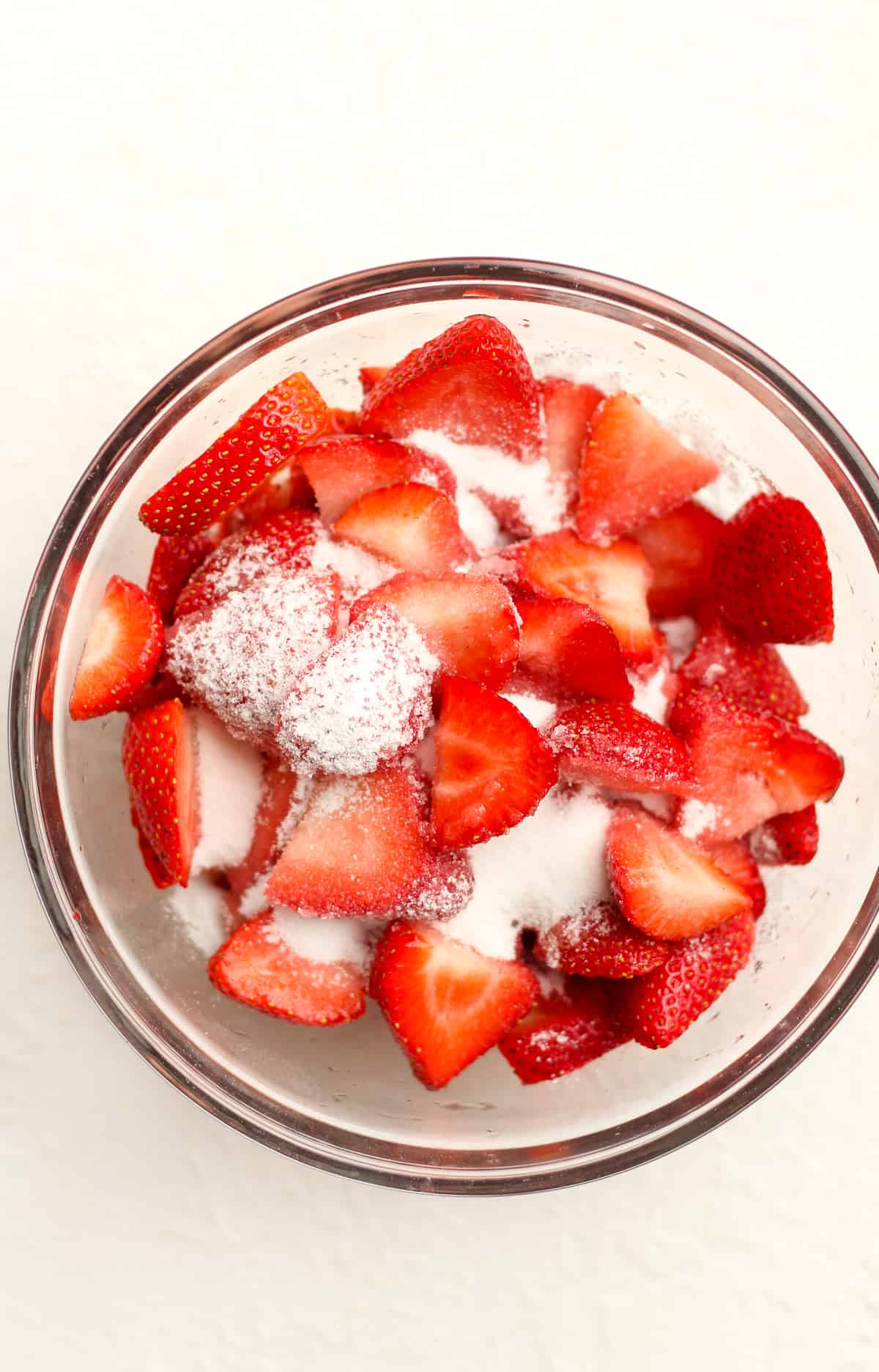 A bowl of shoe sliced strawberries with sugar.