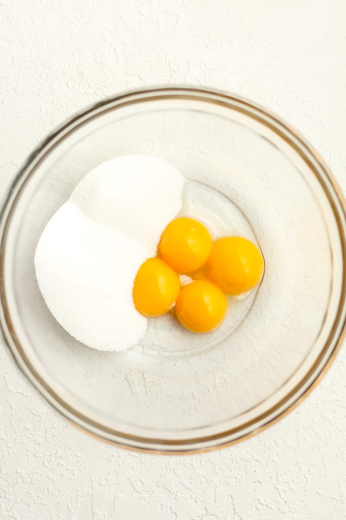 A bowl of four egg yolks plus sugar.
