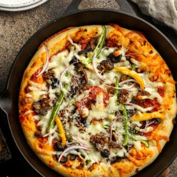 A cast iron of just baked supreme pizza.