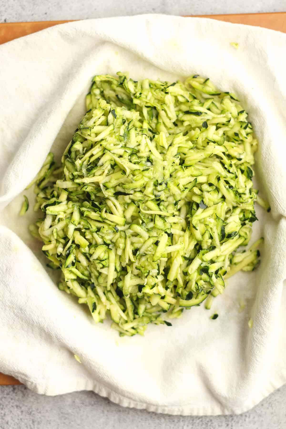 Closeup on the shredded zucchini in a towel.