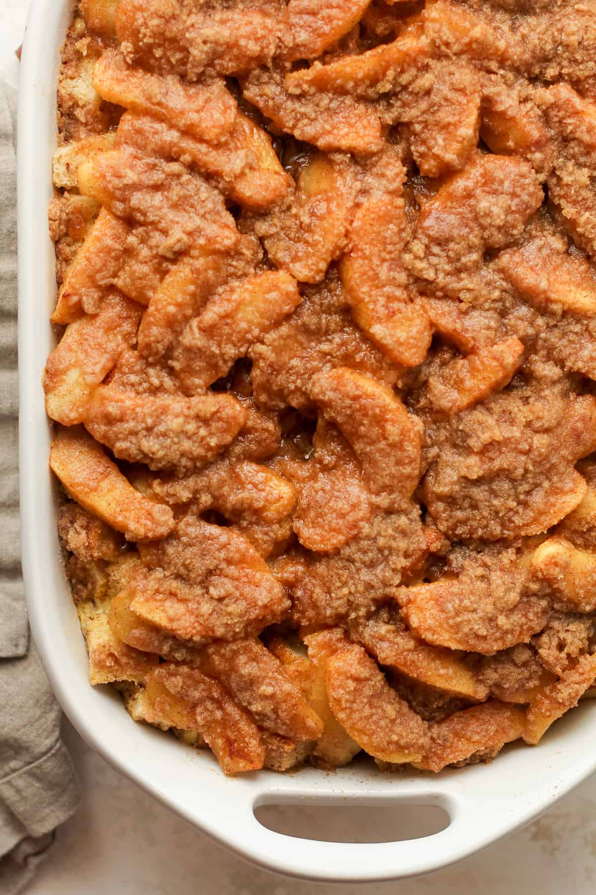 Closeup view of a French Toast Casserole with apple slices and a crumble topping.