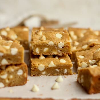 Brown butter white chocolate blondies stacked on a board.