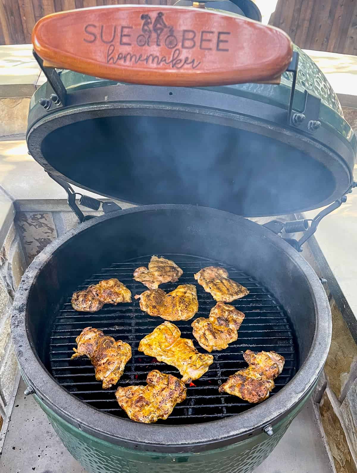 A Big Green Egg with curry chicken thighs.
