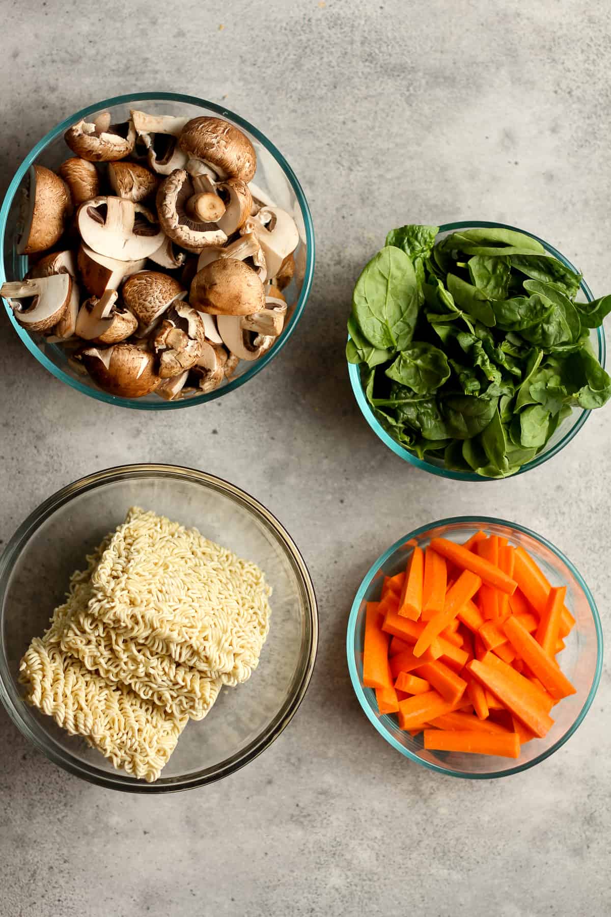 Bowls of the mushrooms, spinach, carrots, and ramen noodles.