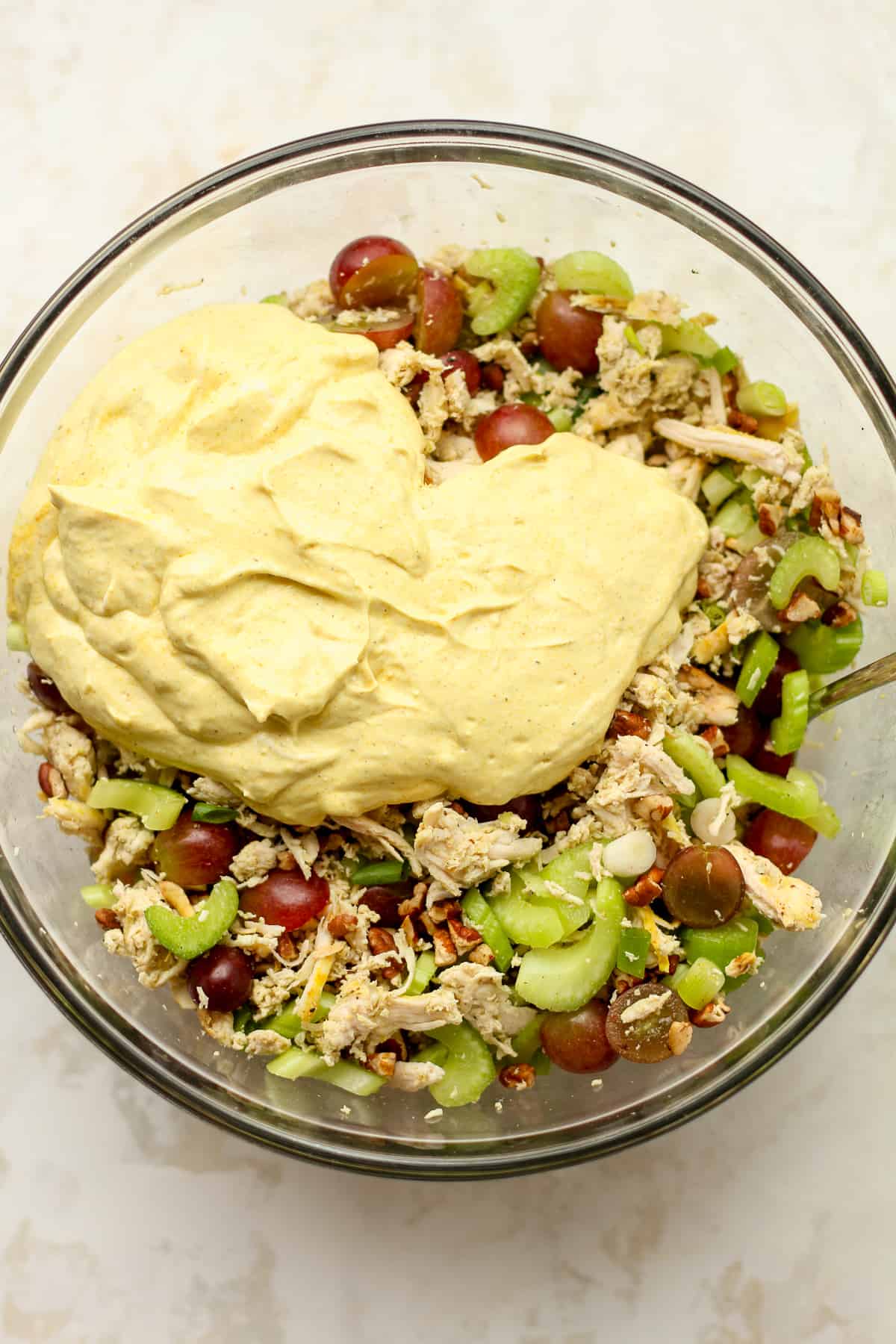 A bowl of the chicken salad with the dressing on top.