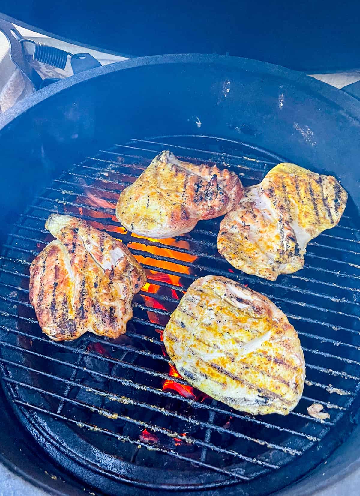 A Big Green Egg with some grilled curry chicken breasts.