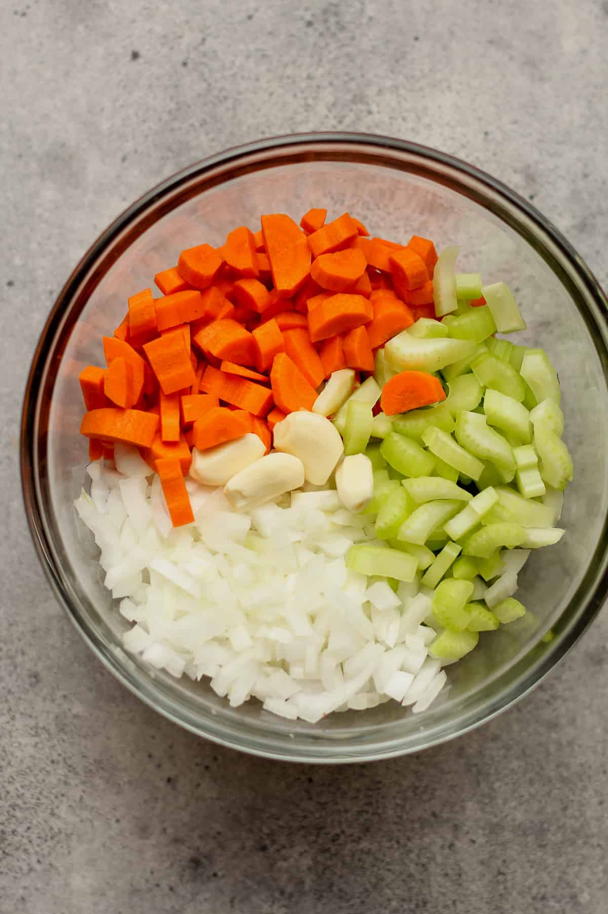 The bowl of chopped carrots, celery, onion, and garlic.