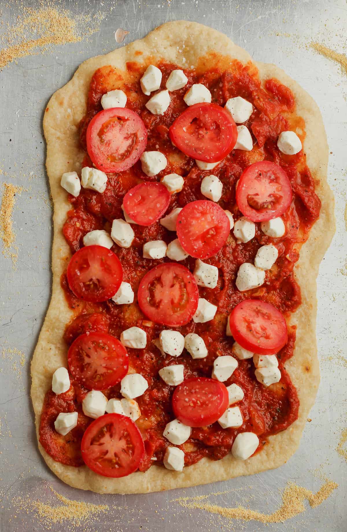 Par-baked flatbread with the toppings on top.