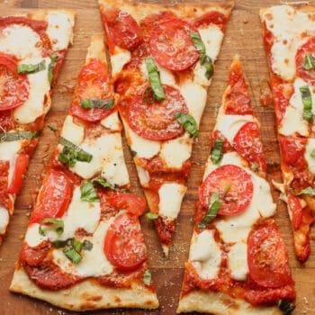 Sliced triangular pieces of flatbread pizza.