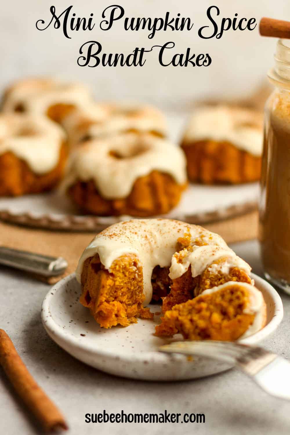 Side view of a mini pumpkin spice bundt cake, with a plate of cakes in the background.