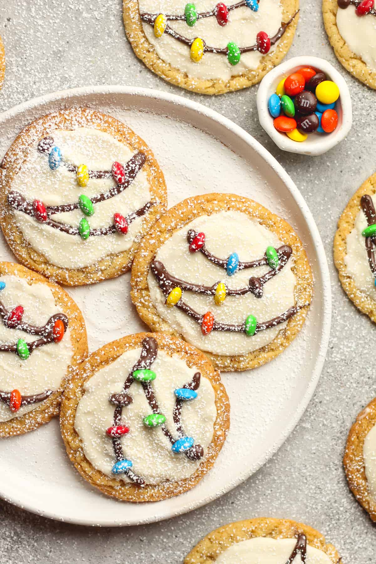 A partial plate of Christmas lights decorated on sugar cookies.