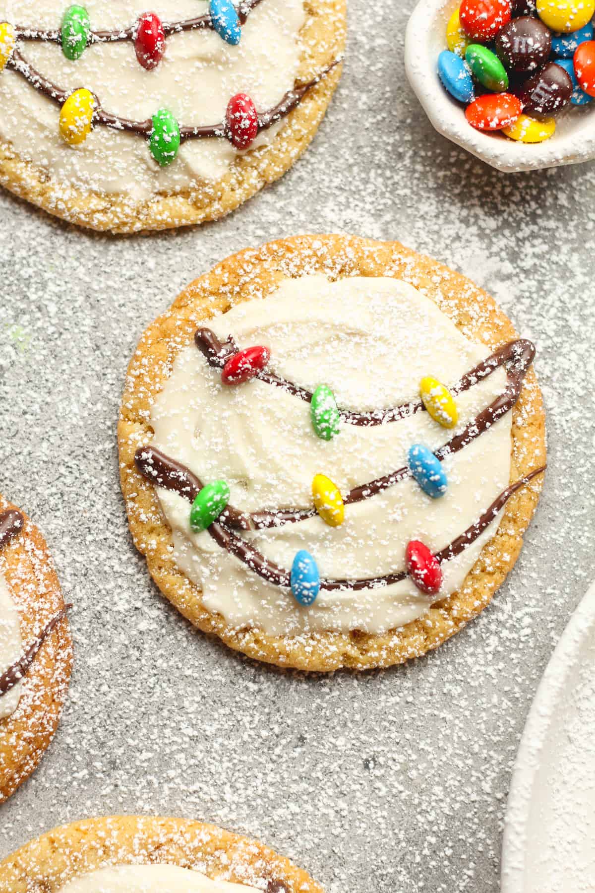 A sugar cookie with white icing and a string of lights.