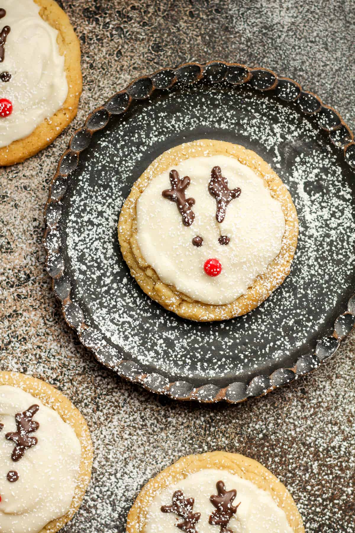 A plate with a reindeer sugar cookie decorated with red hots.