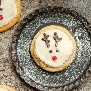 Closeup on a black plate with a reindeer sugar cookies.