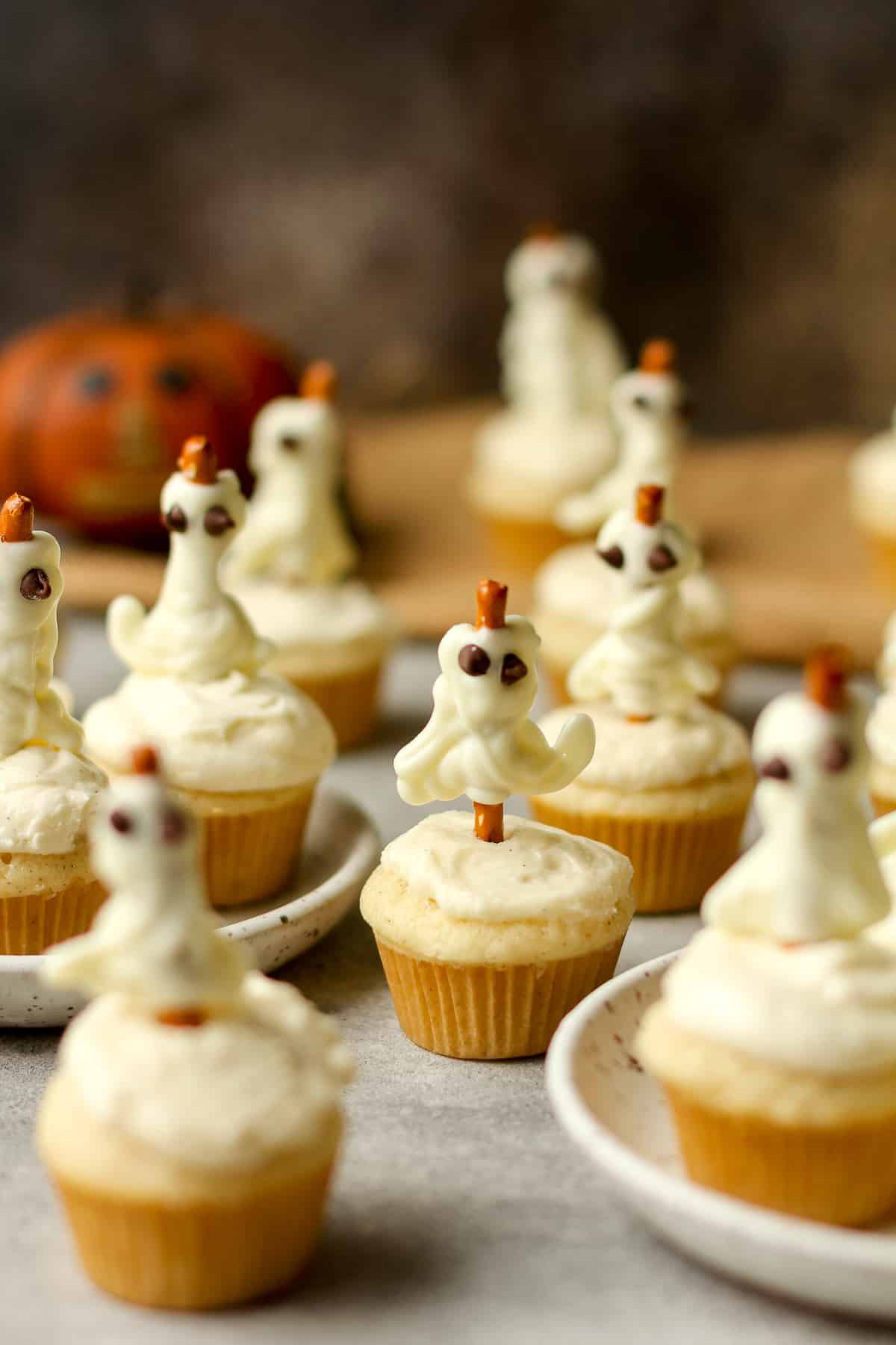 Side view of several Halloween ghost cupcakes.