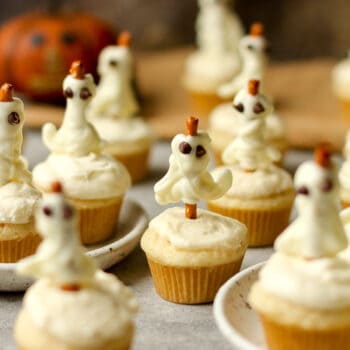 Side view of a bunch of Halloween ghost cupcakes.