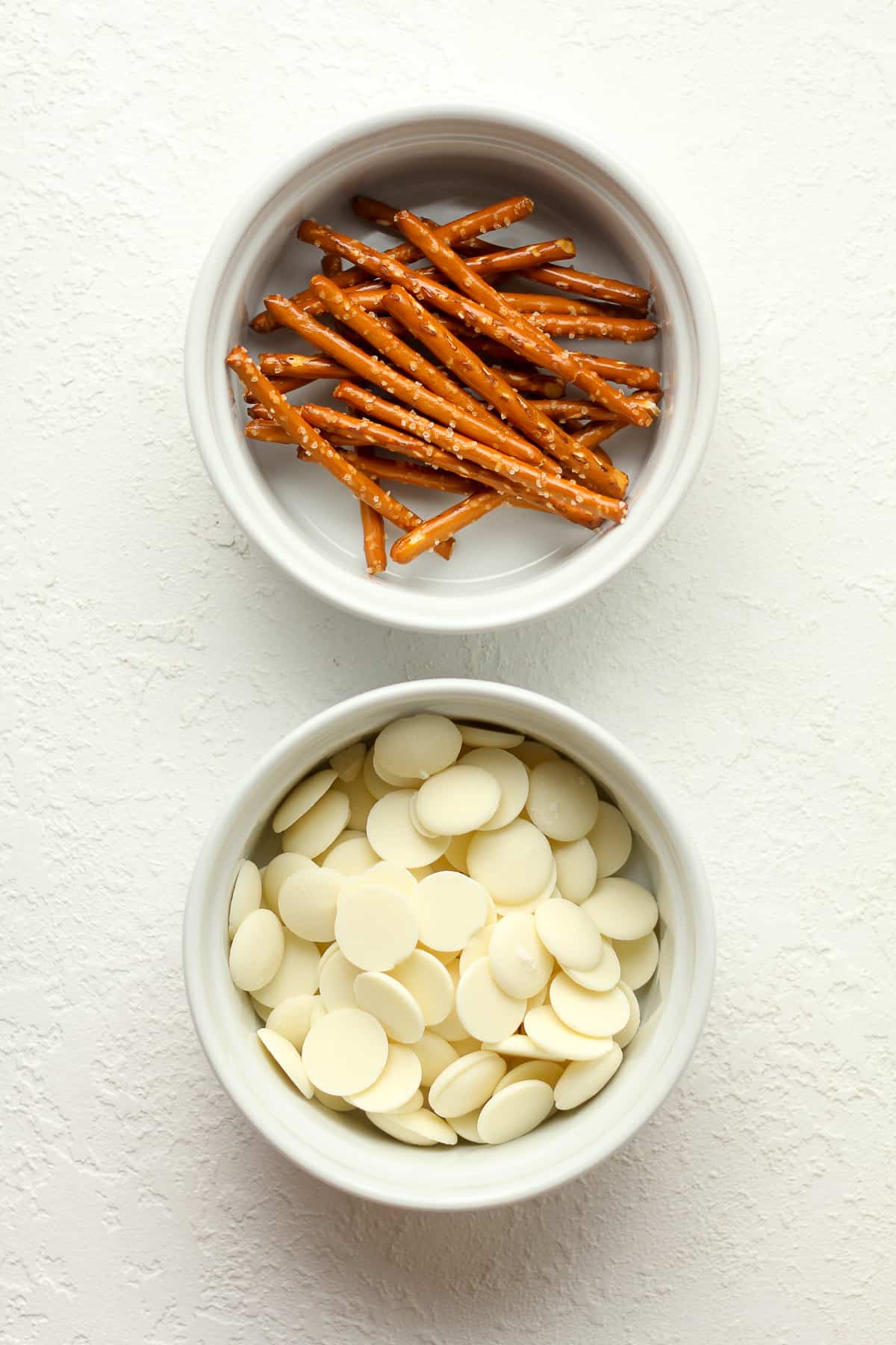 Bowls of pretzel sticks and white chocolate melts.