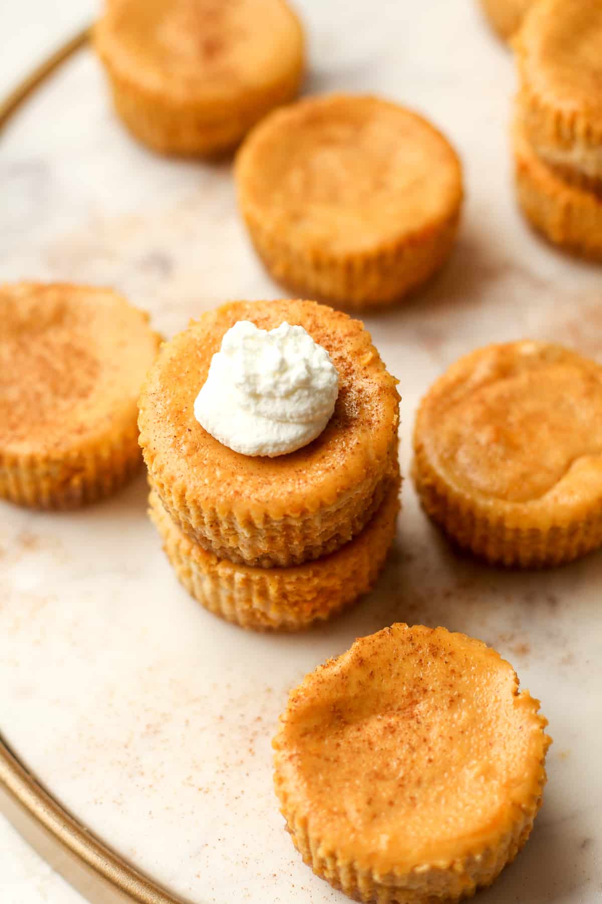 A tray with pumpkin cheesecake bites with two stacked.