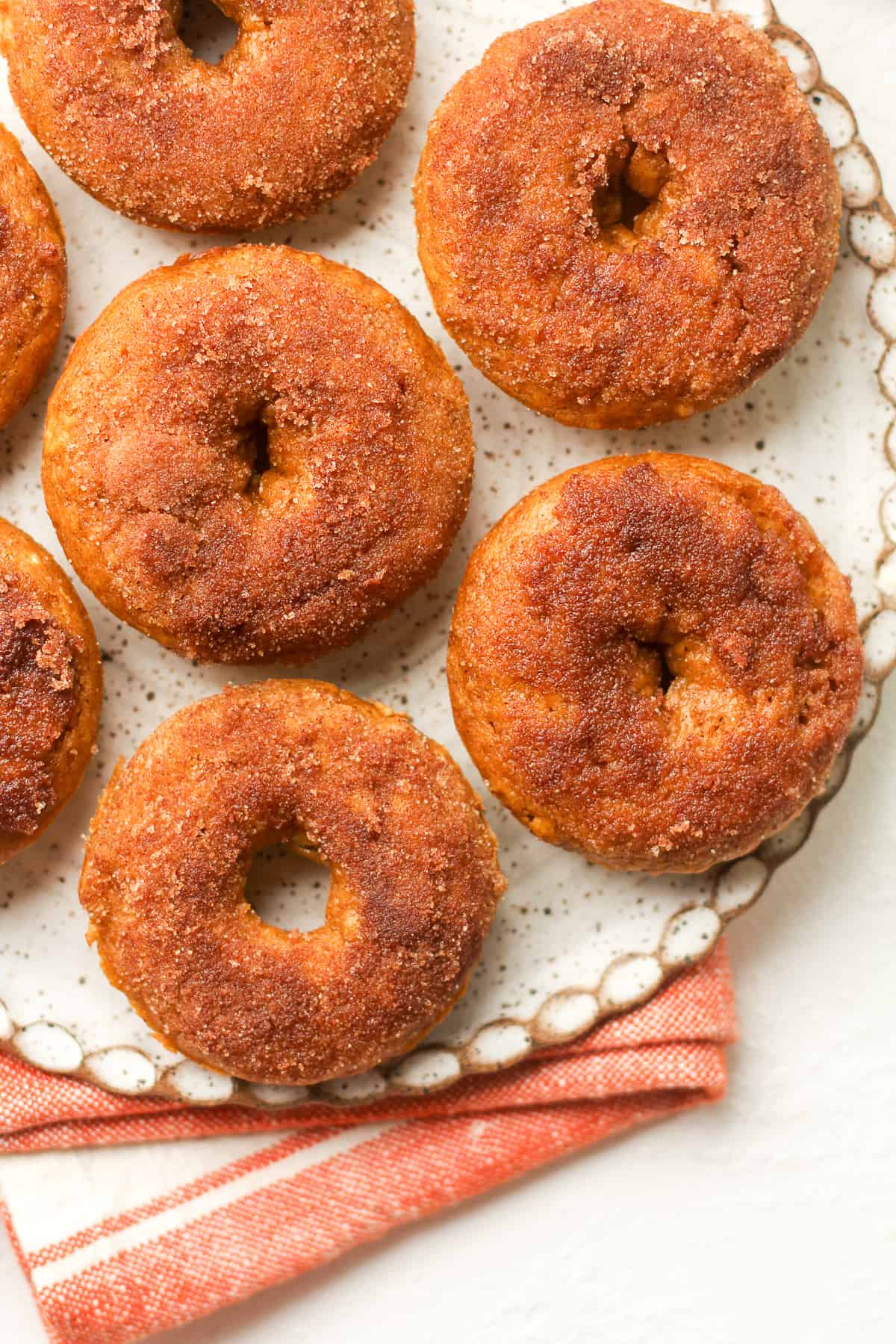 A plate of pumpkin spice donuts with cinnamon topping.